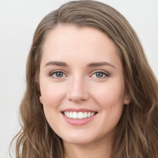 Joyful white young-adult female with long  brown hair and grey eyes