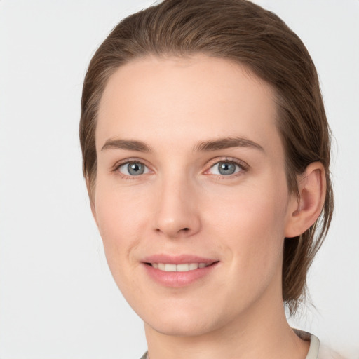 Joyful white young-adult female with medium  brown hair and grey eyes