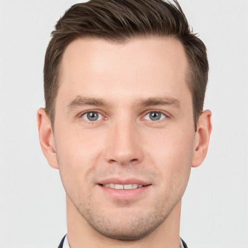 Joyful white young-adult male with short  brown hair and grey eyes