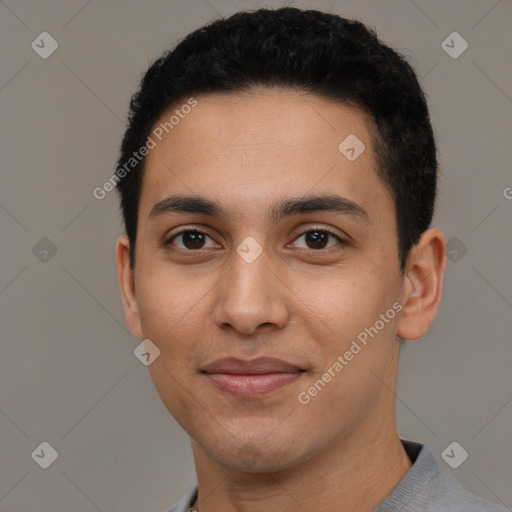 Joyful latino young-adult male with short  black hair and brown eyes