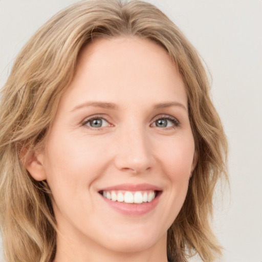 Joyful white young-adult female with medium  brown hair and blue eyes