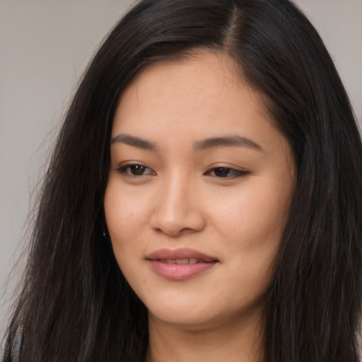 Joyful asian young-adult female with long  black hair and brown eyes