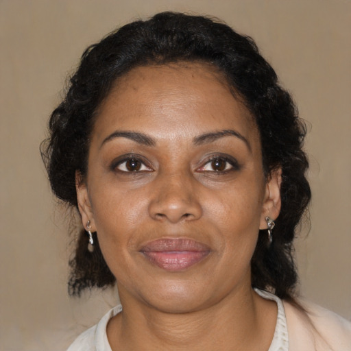 Joyful black adult female with medium  brown hair and brown eyes