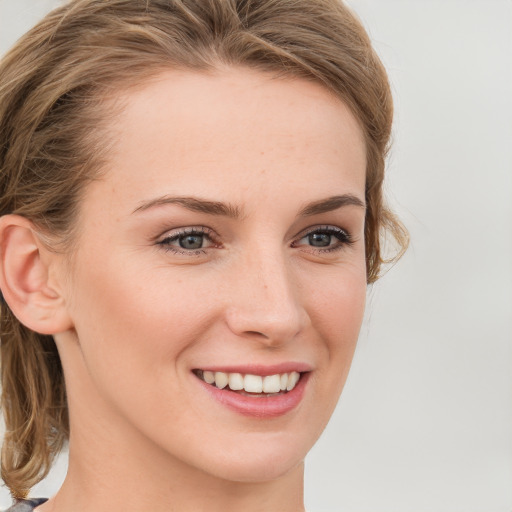 Joyful white young-adult female with medium  brown hair and blue eyes