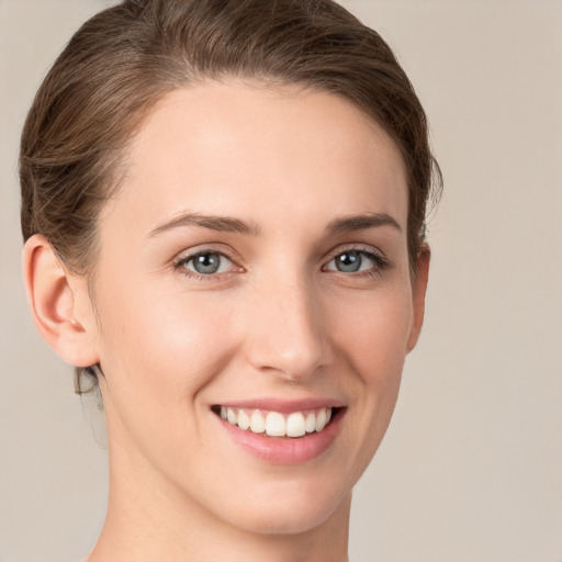 Joyful white young-adult female with short  brown hair and grey eyes