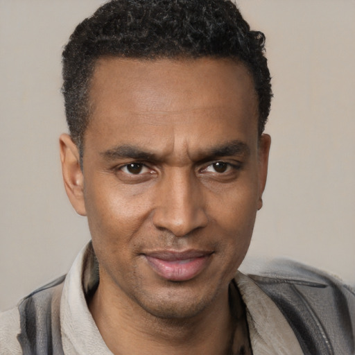 Joyful black adult male with short  black hair and brown eyes