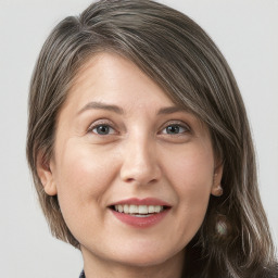 Joyful white adult female with medium  brown hair and grey eyes