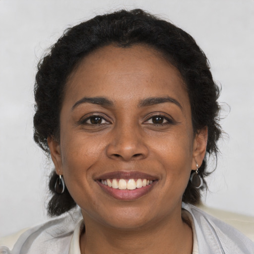 Joyful black young-adult female with short  brown hair and brown eyes