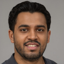 Joyful latino young-adult male with short  black hair and brown eyes