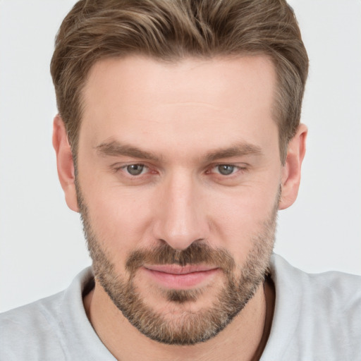 Joyful white young-adult male with short  brown hair and grey eyes