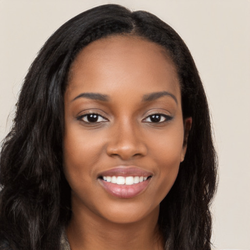 Joyful black young-adult female with long  brown hair and brown eyes