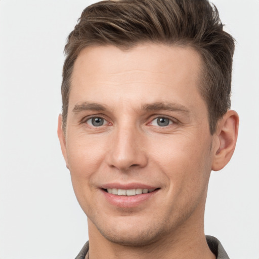 Joyful white young-adult male with short  brown hair and grey eyes