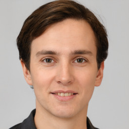 Joyful white young-adult male with short  brown hair and grey eyes