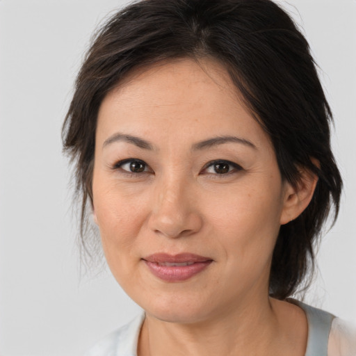 Joyful asian adult female with medium  brown hair and brown eyes