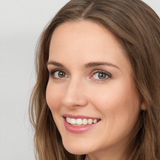 Joyful white young-adult female with long  brown hair and green eyes