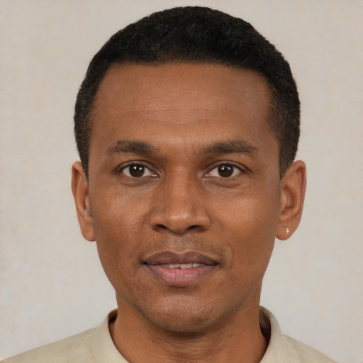Joyful black young-adult male with short  black hair and brown eyes