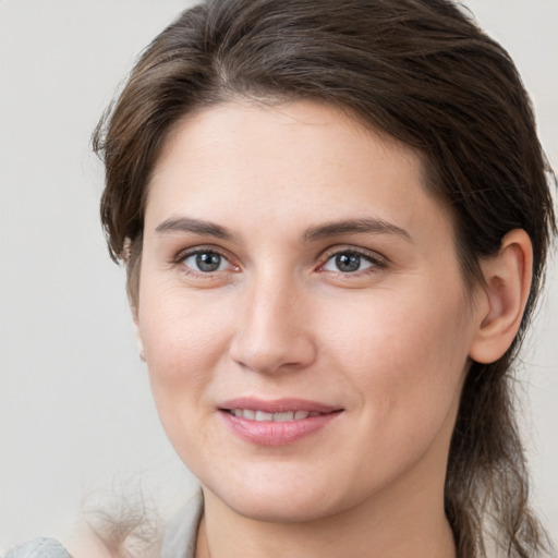 Joyful white young-adult female with medium  brown hair and grey eyes