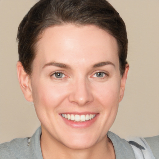 Joyful white young-adult female with short  brown hair and grey eyes