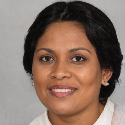 Joyful black adult female with medium  brown hair and brown eyes