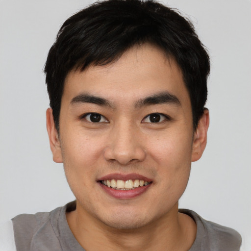 Joyful asian young-adult male with short  brown hair and brown eyes