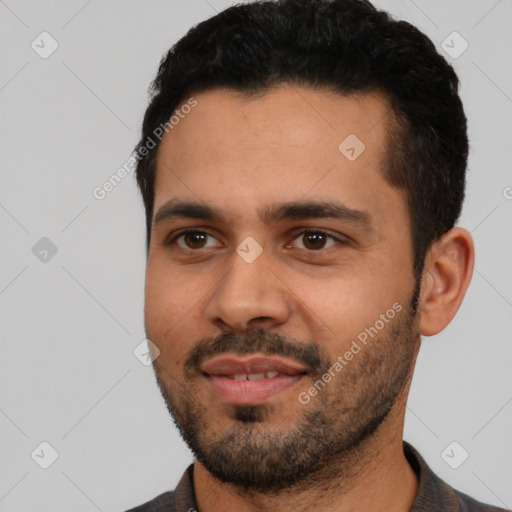 Joyful latino young-adult male with short  black hair and brown eyes