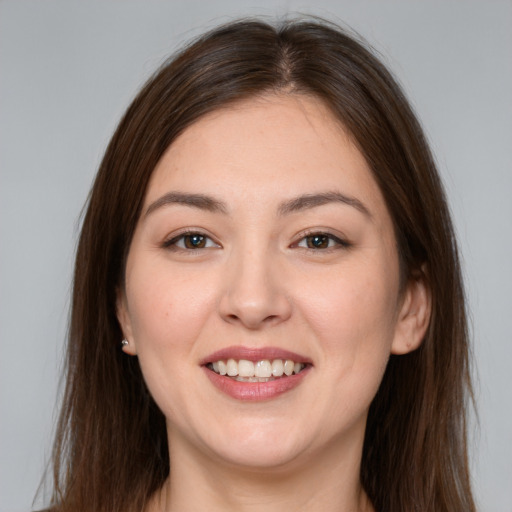 Joyful white young-adult female with long  brown hair and brown eyes