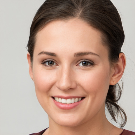 Joyful white young-adult female with medium  brown hair and grey eyes