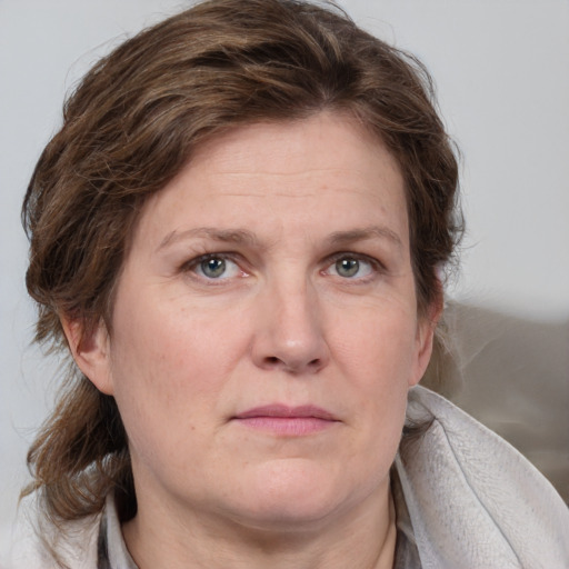 Joyful white adult female with medium  brown hair and blue eyes