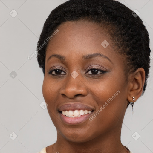 Joyful black young-adult female with short  brown hair and brown eyes