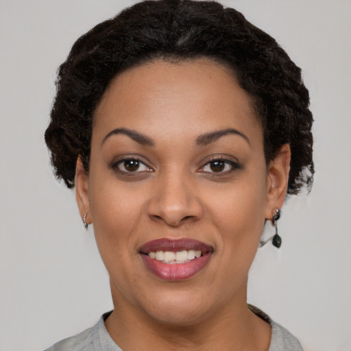 Joyful black young-adult female with short  black hair and brown eyes