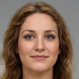 Joyful white young-adult female with long  brown hair and green eyes