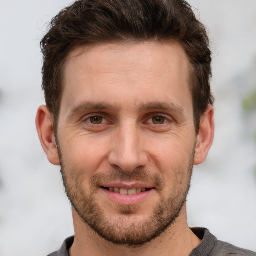 Joyful white adult male with short  brown hair and brown eyes