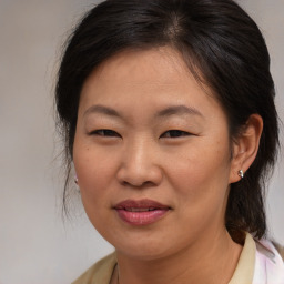 Joyful asian adult female with medium  brown hair and brown eyes