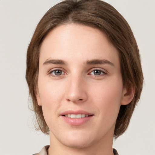 Joyful white young-adult female with medium  brown hair and grey eyes