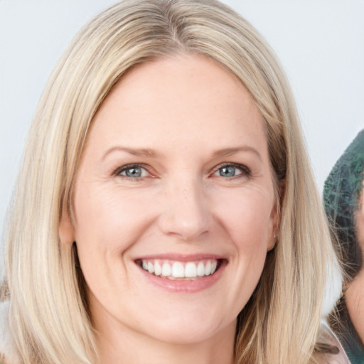 Joyful white adult female with long  brown hair and blue eyes