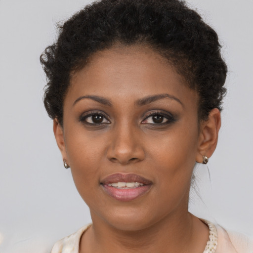 Joyful black young-adult female with short  brown hair and brown eyes