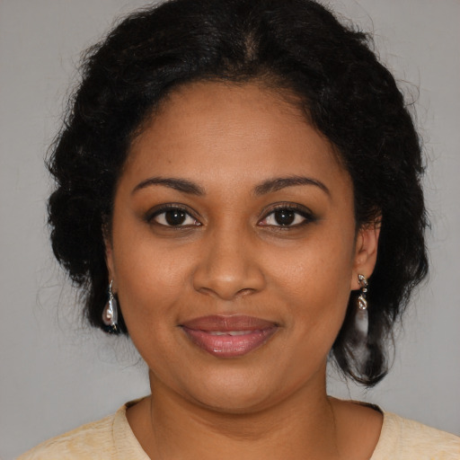 Joyful black young-adult female with medium  brown hair and brown eyes