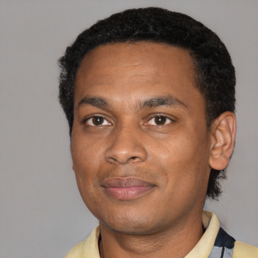 Joyful black young-adult male with short  black hair and brown eyes