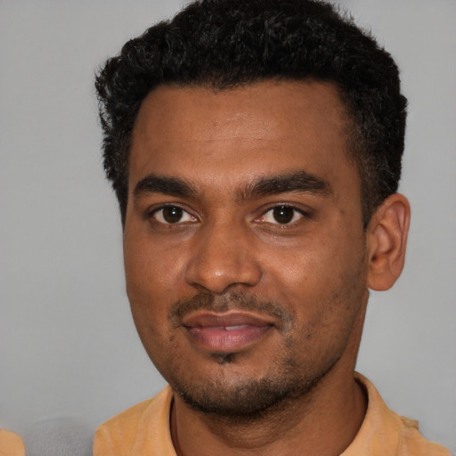 Joyful black young-adult male with short  black hair and brown eyes