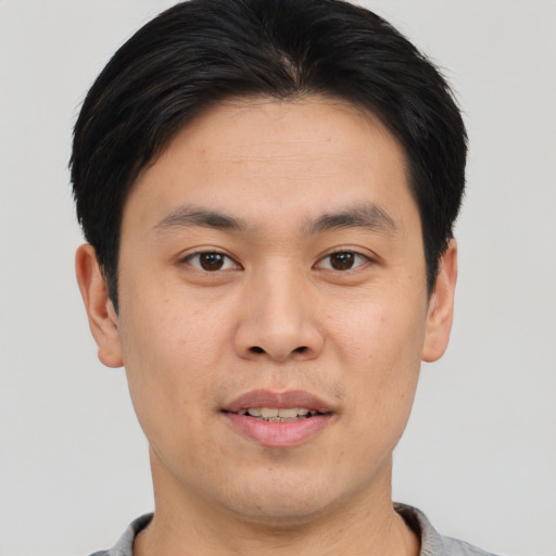 Joyful asian young-adult male with short  black hair and brown eyes