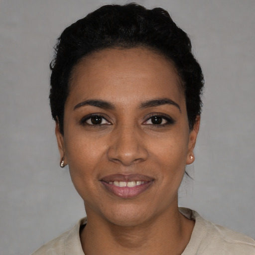 Joyful black young-adult female with short  black hair and brown eyes