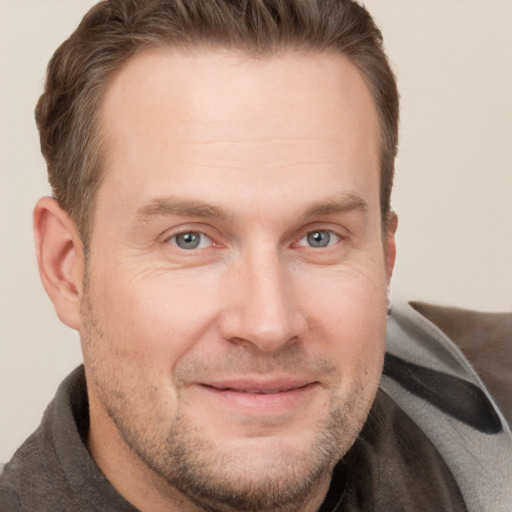 Joyful white adult male with short  brown hair and grey eyes