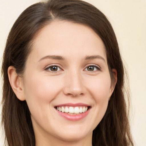 Joyful white young-adult female with long  brown hair and brown eyes