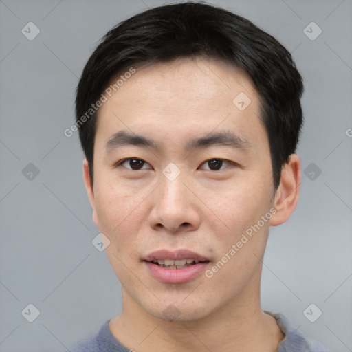 Joyful asian young-adult male with short  black hair and brown eyes