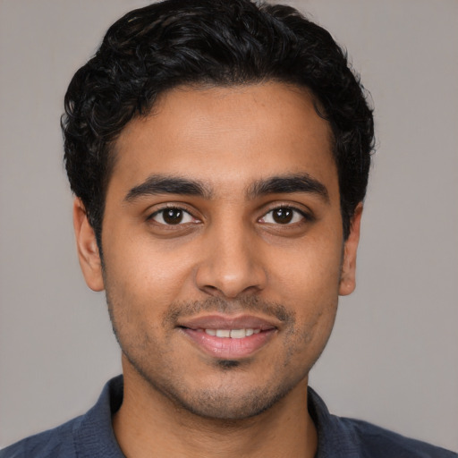 Joyful latino young-adult male with short  black hair and brown eyes