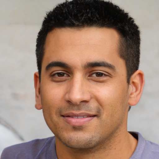 Joyful latino young-adult male with short  black hair and brown eyes