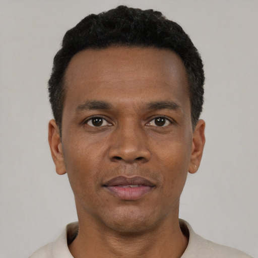 Joyful black young-adult male with short  black hair and brown eyes