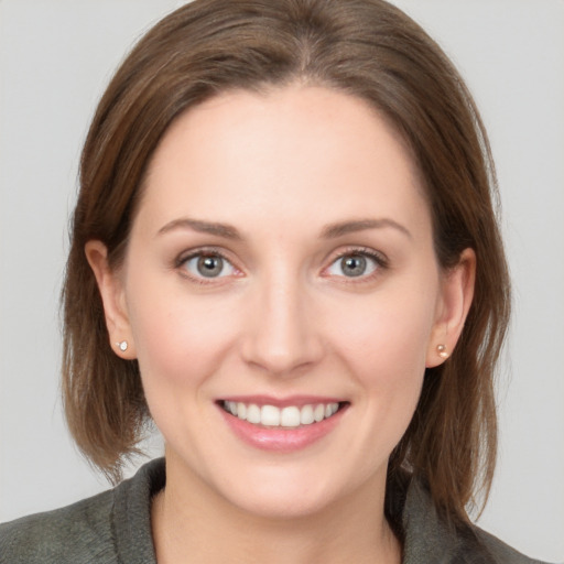 Joyful white young-adult female with medium  brown hair and grey eyes