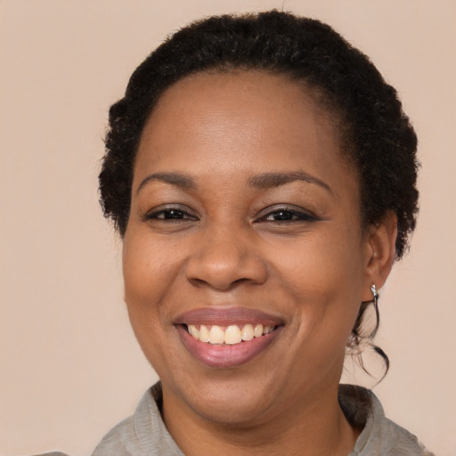 Joyful black adult female with short  brown hair and brown eyes