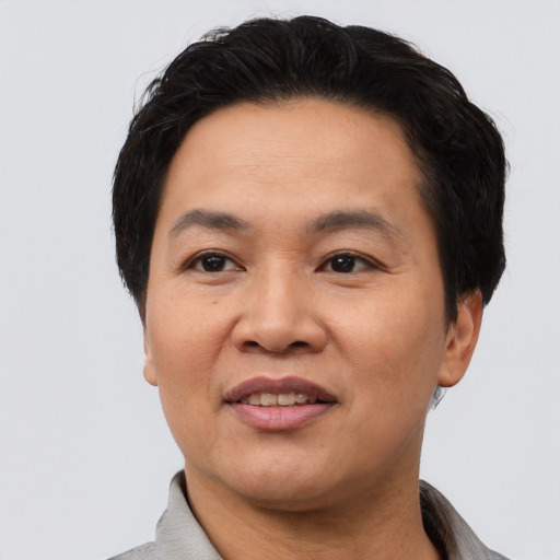Joyful asian adult male with short  black hair and brown eyes